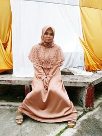 Portrait of mid adult woman wearing traditional clothing sitting outdoors