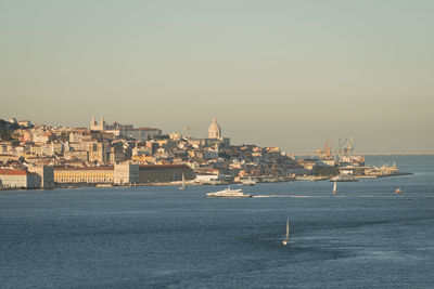 View of townscape by sea against clear sky