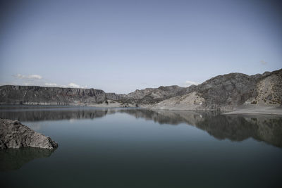 Scenic view of lake and mountains against clear blue sky