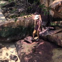 Full length of woman standing on rock in cave