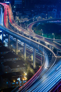 Aerial view of light trail on highway in city at night