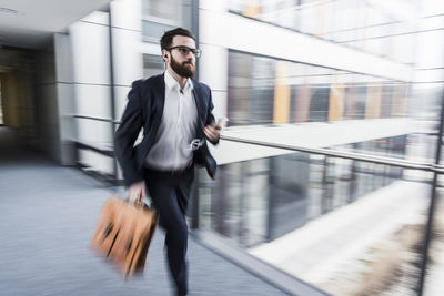 Businessman running in corridor of an office building