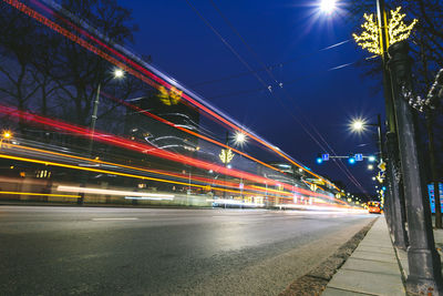 Light trails on road against sky at night