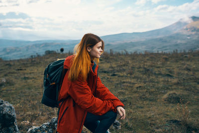 Young woman standing on land against sky