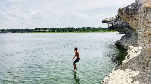 Young woman in water against sky