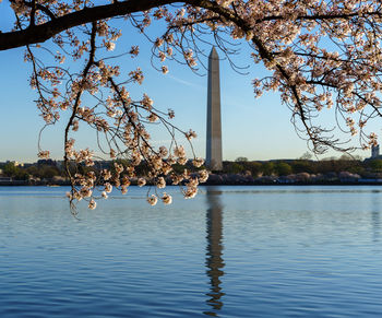 Reflection of monument in lake against sky during springtime