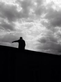 Low angle view of silhouette tree against cloudy sky