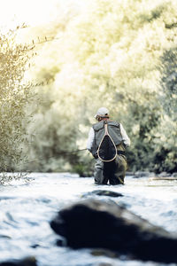 Man fishing in lake at forest