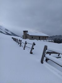 Built structure on snow covered field against sky