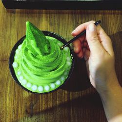 High angle view of hand with ice cream on table