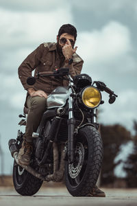 Man riding motorcycle with sunglasses retro look