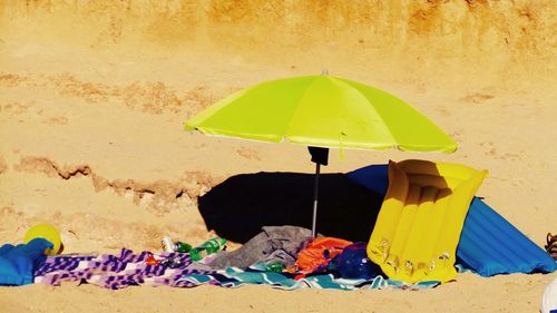 Umbrella and towels at sandy beach on sunny day