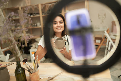 Smiling woman vlogging at home