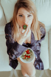 Portrait of woman eating food at home