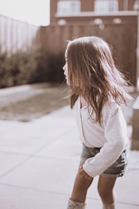 Rear view of woman standing against wall