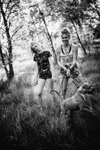 Friends playing with dog on grassy field at park