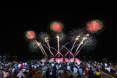 People watching firework display at night