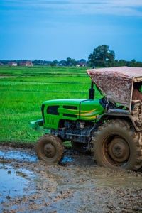 Tractor on agricultural field against sky