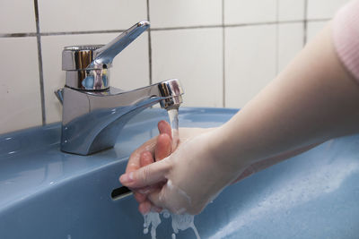 Cropped hands washing hands in sink