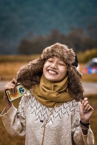 Smiling young woman wearing warm clothing on field