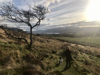 Man walking on field against sky
