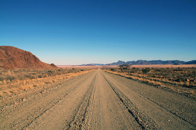 Empty road along countryside landscape