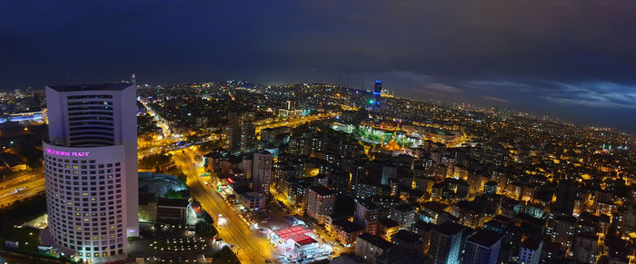 High angle view of illuminated buildings against sky at night