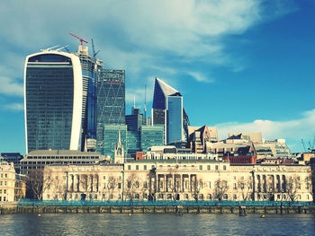 View of buildings in city against cloudy sky