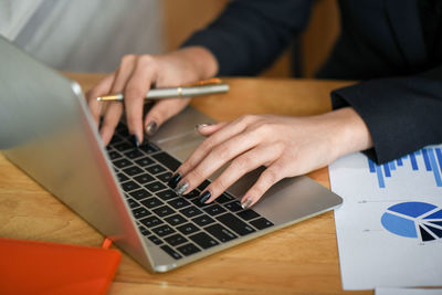 Midsection of man using laptop on table