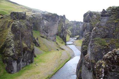Scenic view of river by mountains against clear sky