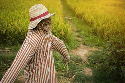 Rear view of person wearing hat on field