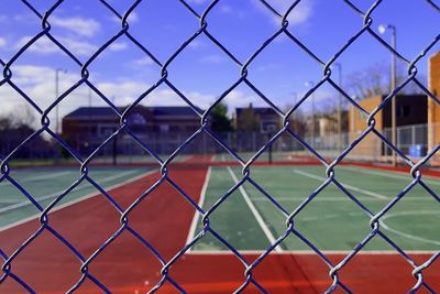 Full frame shot of soccer field seen through chainlink fence