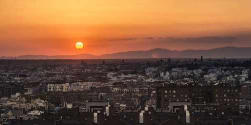 Partial sun eclipse over madrid skyline on a warm summer sunset