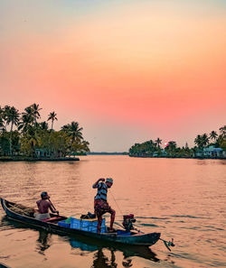 People on boat against sky during sunset