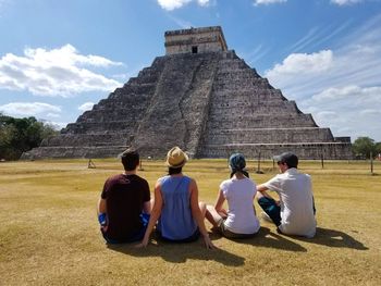 Rear view of people sitting outside temple