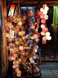 Close-up of illuminated lanterns hanging at market stall
