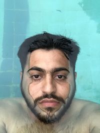 Portrait of handsome young man in swimming pool