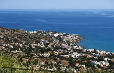 High angle view of town by sea against sky