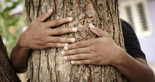 Close-up of hands making tree trunk