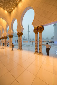 People walking in corridor of historical building