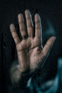 Close-up of hand on wet glass