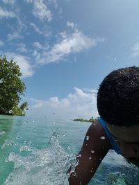 Portrait of man swimming in sea against sky