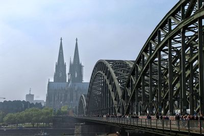 Bridge by buildings against sky in city