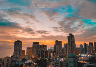 Skyscrapers in city against sky during sunset