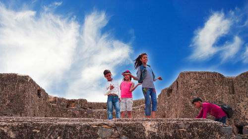 People standing on mountain against sky