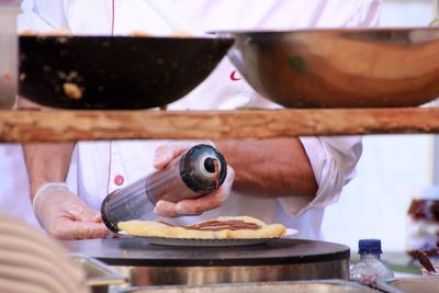 Midsection of male chef preparing food in kitchen