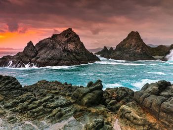 Rock formations at seaside during sunset