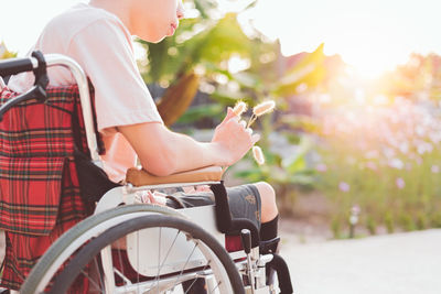 Midsection of man sitting on wheelchair