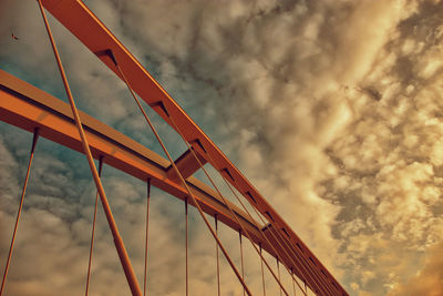 Low angle view of suspension bridge against sky during sunset