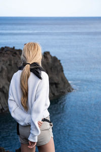 Rear view of woman standing at beach